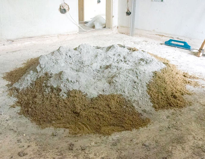 Trabajador de la construcción preparando mezcla de cemento portland blanco