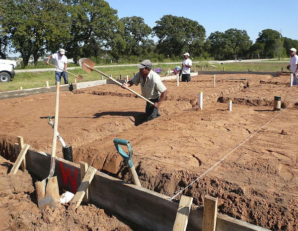 Trabajadores excavando las zanjas en las que irán los cimientos Trabajadores excavando las zanjas en las que irán los cimientos