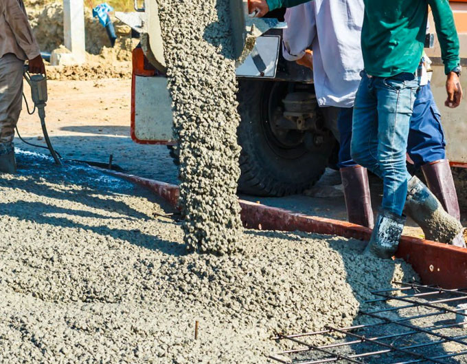Albañiles colocando concreto premezclado en una obra Albañiles colocando concreto premezclado en una obra
