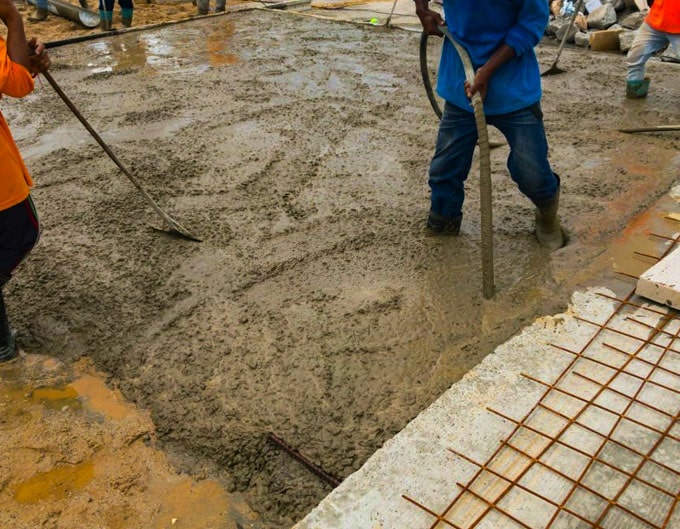 Trabajador vibrando hormigón en obra Trabajador vibrando hormigón en obra