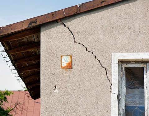 Una grieta estructural que se ve debajo de la ventana en un muro de concreto - grietas en muros