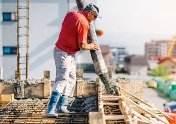 Un trabajador aplica concreto proyectado con una manguera