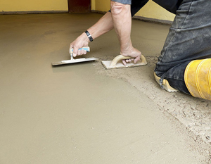 Albañiles alisando un piso de concreto con lisas y llanas Albañiles alisando un piso de concreto con lisas y llanas