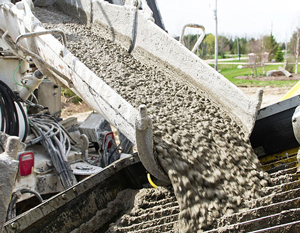 Trabajadores de la construcción controlando la manguera del concreto bombeado Trabajadores de la construcción controlando la manguera del concreto bombeado