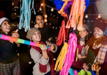 Niños rompiendo una piñata durante una posada de la época de Navidad en México