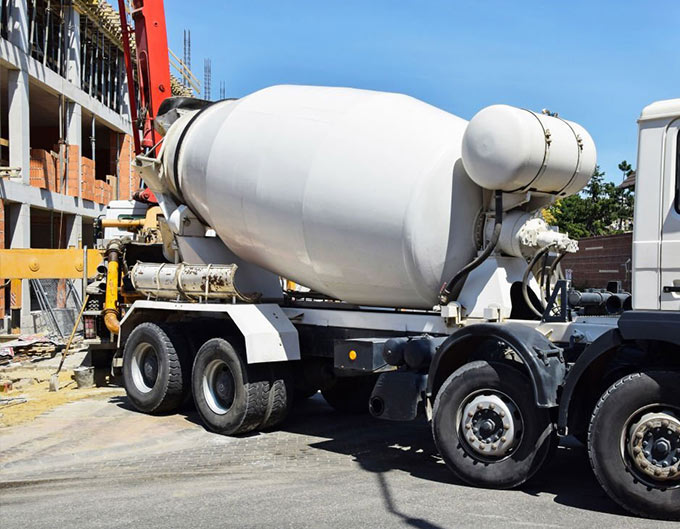 Camiones revolvedora de concreto estacionados frente a un sitio de construcción. Camiones revolvedora de concreto estacionados frente a un sitio de construcción.