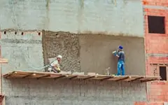 Trabajadores realizando el aplanado de un muro en una construcción