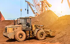 Vehículo tipo retroexcavadora transportando arena en una cantera